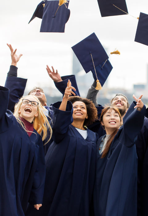 students tossing their graduation caps